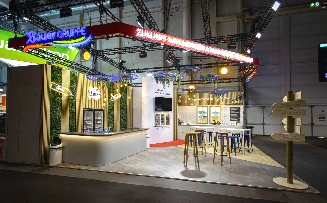 Schr&auml;gansicht des Bauer-Messestands auf der OMR 2025 mit Empfangs- und Cateringbereich.