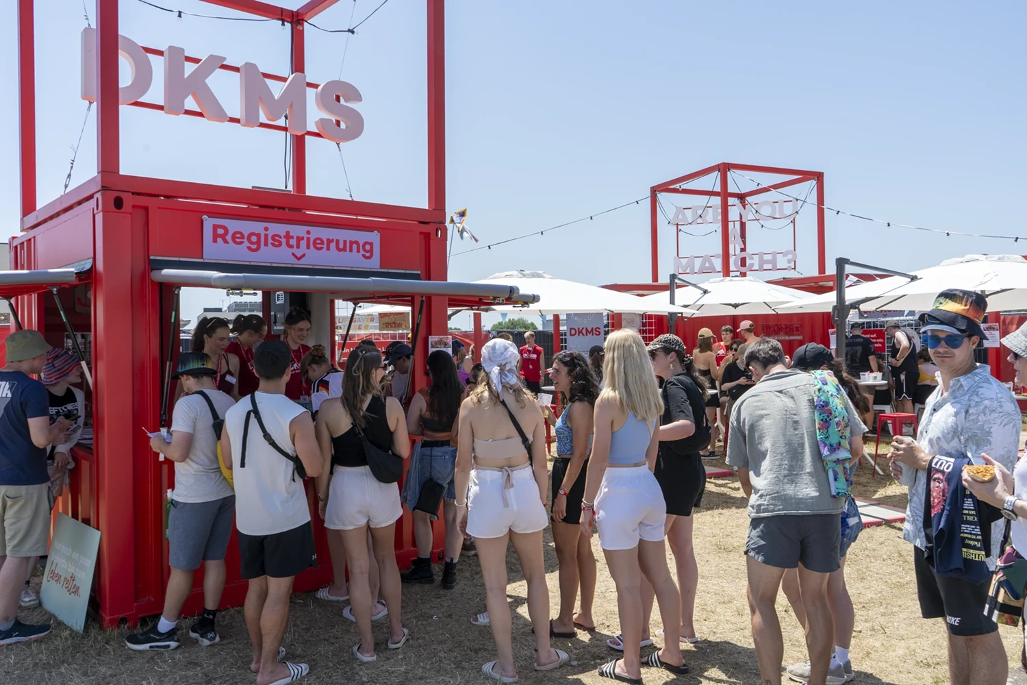 Junge Festivalbesucher stehen am DKMS-Festivalstand Schlange, um sich zu registrieren.