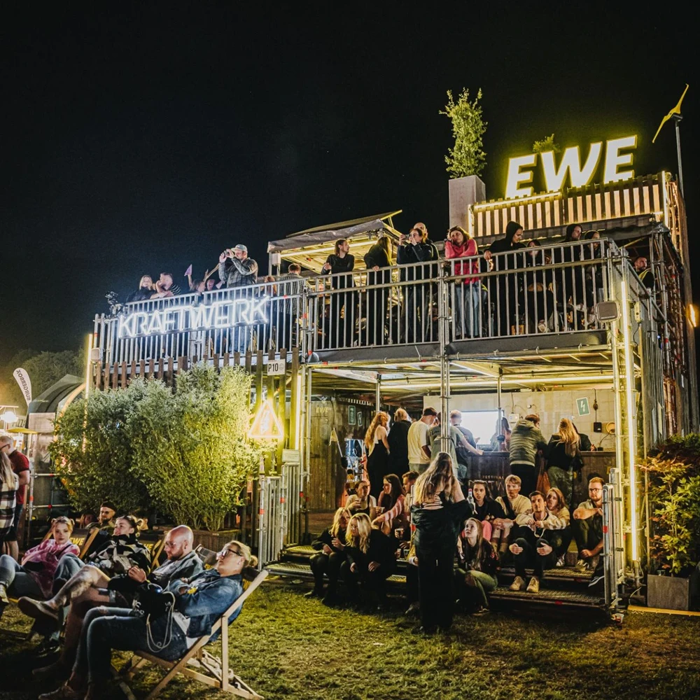Festivalbesucher genie&szlig;en den Abend auf den beiden Ebenen des EWE Kraftwerks mit Lounge, Bar und Aussichtsplattform.