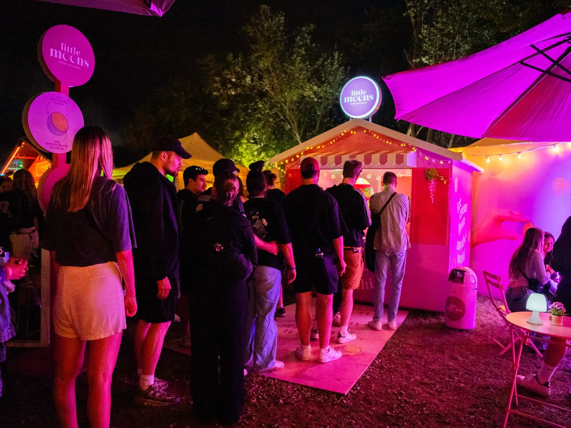 Festivalbesucher stehen am beleuchteten Little-Moons-Festival-Garden an.