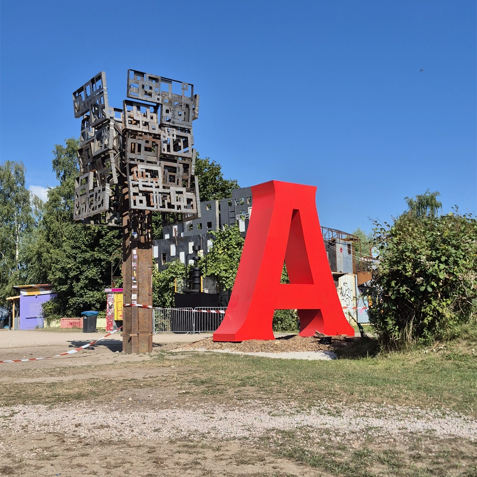 &Uuml;berdimensionaler roter 3-D Buchstabe auf dem Festivalgel&auml;nde.